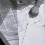 Planos de arquitectura y herramientas de trabajo sobre una mesa