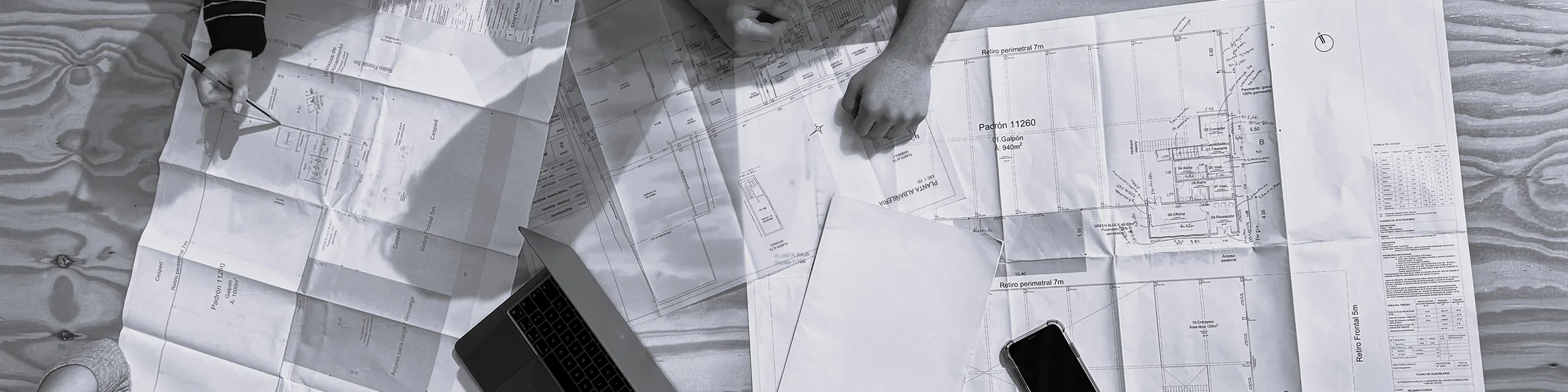 Planos de arquitectura y herramientas de trabajo sobre una mesa